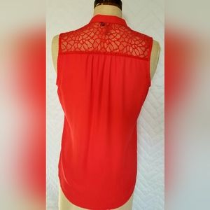 Sleeveless blouse with embroidered detailing, and lace upperback.